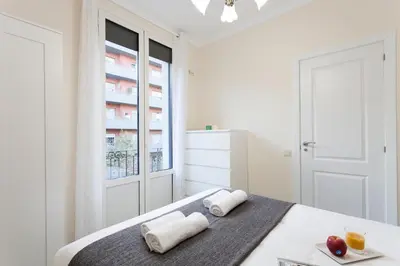 a white bedroom with a bed and a window at 2582 - AB Sagrada Familia Marina in Barcelona