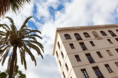 a tall building with a palm tree next to it at Barceloneta Mar Beach - BM32 in Barcelona