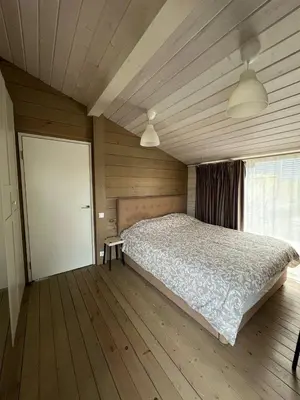 a bedroom with a large bed and a wooden floor at La Dacha Montanya in Seva