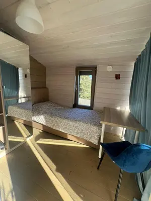 a small room with a bed and a chair at La Dacha Montanya in Seva