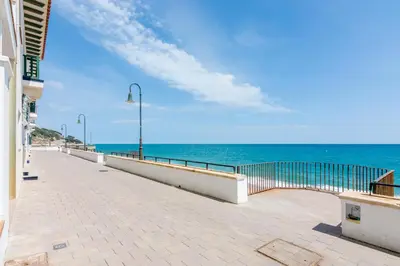 a walkway next to the ocean on a beach at HomeHolidaysRentals Suria - Costa Barcelona in San Pol de Mar