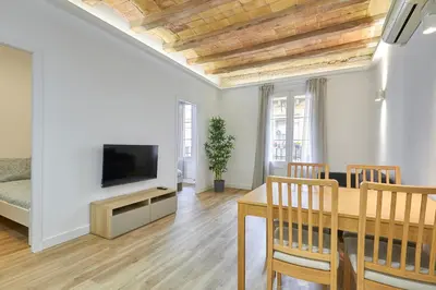 a living room with a dining room table and a television at Ro Lively and bright apartment next to Blai st in Barcelona
