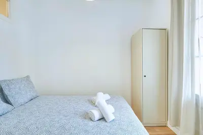 a white teddy bear sitting on top of a bed at Ro Lively and bright apartment next to Blai st in Barcelona