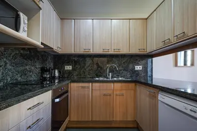 a kitchen with wooden cabinets and a sink at Gran Via City Center Apartment in Barcelona