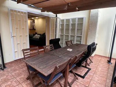 a wooden table and chairs in a living room at Ramblas Rentals Central Duplex 4BR Terrace Pool Table & Ping Pong in Barcelona