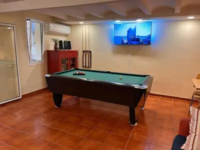 a room with a pool table and a tv on the wall at Ramblas Rentals Central Duplex 4BR Terrace Pool Table & Ping Pong in Barcelona