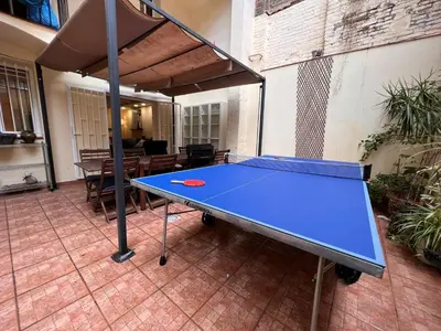 a ping pong table in the middle of a patio at Ramblas Rentals Central Duplex 4BR Terrace Pool Table & Ping Pong in Barcelona