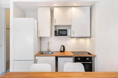 a kitchen with white cabinets and white appliances at Lodging Apartments Pere IV in Barcelona