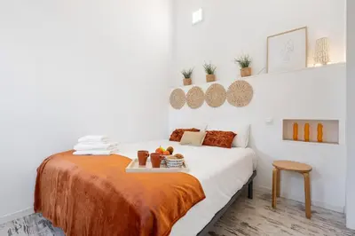 a bedroom with a bed with a tray of food on it at Lodging Apartments Pere IV in Barcelona