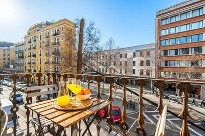 a table on a balcony with a view of a street at Lodging Apartments Pere IV in Barcelona