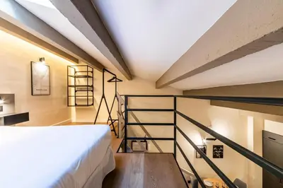 a loft bedroom with a bed and a staircase at Petit Luxe Del Vall in Terrassa