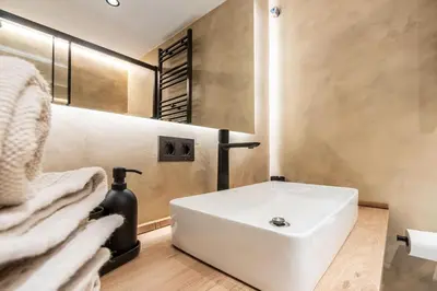 a bathroom with a white sink and a chair at Petit Luxe Del Vall in Terrassa