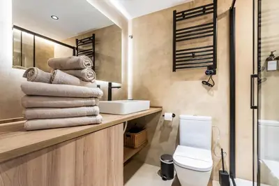 a bathroom with a toilet and a sink and towels at Petit Luxe Del Vall in Terrassa