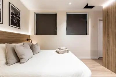 a bedroom with a white bed with three windows at Petit Luxe Mutua in Terrassa