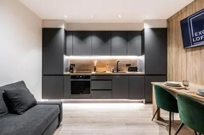 a kitchen with black cabinets and a couch in a room at Petit Luxe Mutua in Terrassa