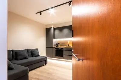 a living room with a couch and a wooden door at Petit Luxe Mutua in Terrassa