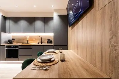 a dining room with a table and a kitchen at Petit Luxe Mutua in Terrassa