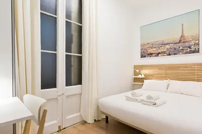 a bedroom with a white bed and a window at Barcelona Central Park II in Barcelona