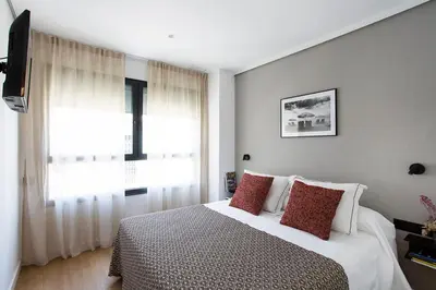 a bedroom with a bed with red pillows and a window at Durlet Suites by Durlet Apartments in Barcelona