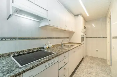 a kitchen with white cabinets and a sink at Side Sea Cunit sea views in Cunit