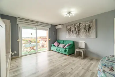 a living room with a green couch and a window at Side Sea Cunit sea views in Cunit