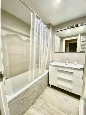a bathroom with a tub and a sink and a mirror at Precioso apartamento al lado de Barcelona centro in Sant Feliu de Llobregat