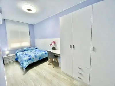 a bedroom with a bed and a desk and a table at Precioso apartamento al lado de Barcelona centro in Sant Feliu de Llobregat