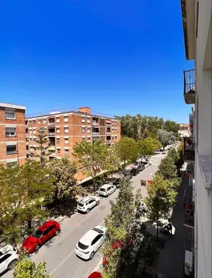 a city street with cars parked in a parking lot at Precioso apartamento al lado de Barcelona centro in Sant Feliu de Llobregat