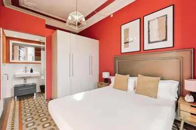 a bedroom with a large white bed and a sink at Ola Living Arc de Triomf in Barcelona