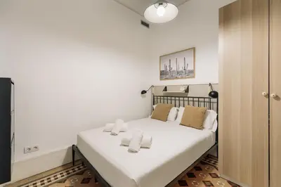 a bedroom with a bed with white sheets and pillows at Ola Living Arc de Triomf in Barcelona