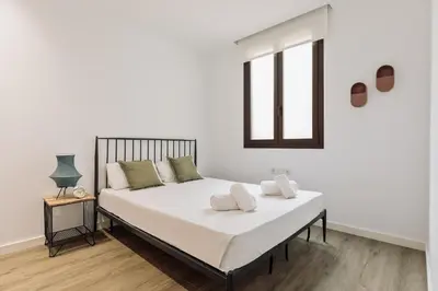 a bedroom with a bed with white sheets and a window at Ola Living Arc de Triomf in Barcelona