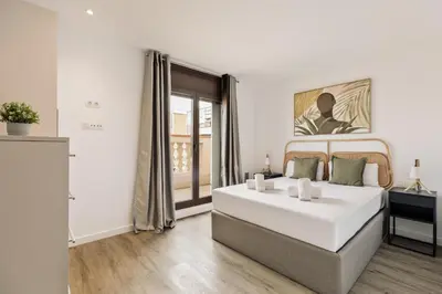 a white bedroom with a large bed and a window at Ola Living Arc de Triomf in Barcelona