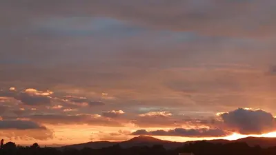 a cloudy sky at sunset with mountains in the background at Parc du Montnegre avec magnifique vue mer in Tordera