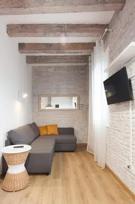 a living room with a couch and a brick wall at Flat with balcony next to the beach, SV in Barcelona