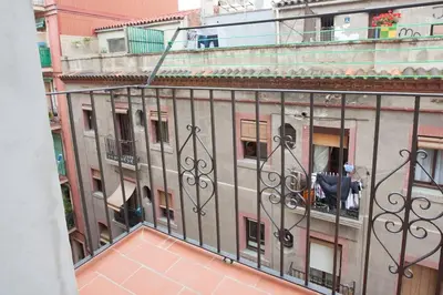 a man sitting on a balcony of a building at Flat with balcony next to the beach, SV in Barcelona