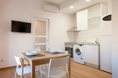 a kitchen and dining room with a table and chairs at Renovated apartment with sea view, VJ in Barcelona