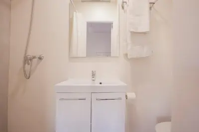 a white bathroom with a sink and a mirror at Renovated apartment with sea view, VJ in Barcelona