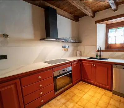 a kitchen with wooden cabinets and a stove top oven at Apartamento montaña en Arties in Artés