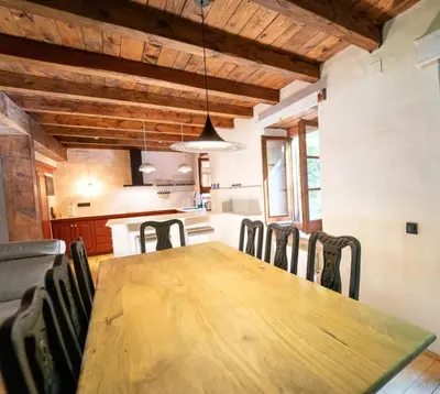 a dining room with a wooden table and chairs at Apartamento montaña en Arties in Artés