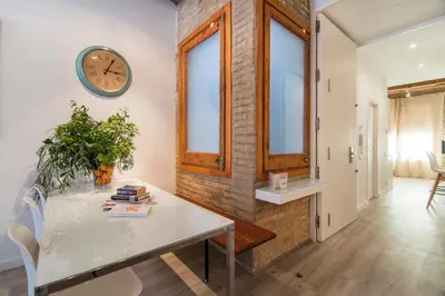a room with a table and a clock on the wall at Happy People Sagrada Familia Apartments in Barcelona