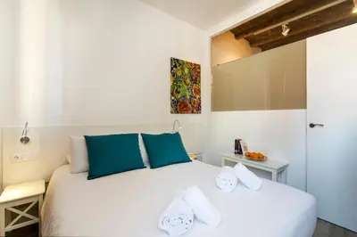 a bedroom with a large white bed with blue pillows at Happy People Sagrada Familia Apartments in Barcelona