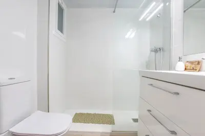 a white bathroom with a toilet and a shower at Penelope Apart in Sitges