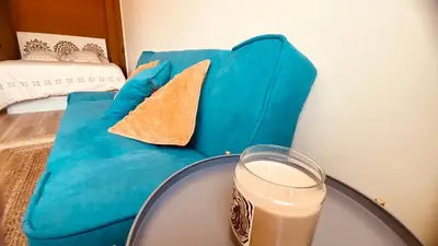 a blue couch with a table and a glass of milk at LEB Apartments in Pineda de Mar