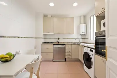 a white kitchen with a table and a dishwasher at Verdaguer Apartments by Central in Barcelona