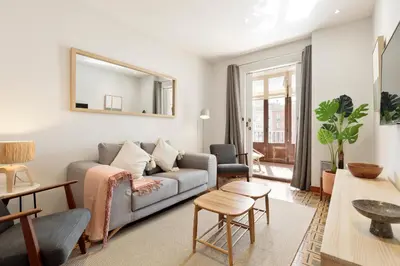 a living room with a couch and a mirror at Verdaguer Apartments by Central in Barcelona