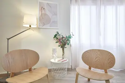 two chairs in a living room with a vase of flowers at BBarcelona Encants Flat in Barcelona