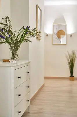 a white dresser with a vase of flowers on it at BBarcelona Encants Flat in Barcelona