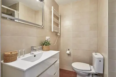 a bathroom with a white toilet and a sink at BBarcelona Encants Flat in Barcelona