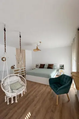 a bedroom with a hammock and a bed and a chair at SUITE Bougainvillea in Lliçà d'Amunt