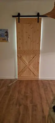 a large wooden door in a room with a wooden floor at SUITE Bougainvillea in Lliçà d'Amunt